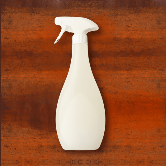 A bottle of Spray-X rust accelerator displayed against a weathered Corten steel background, showing its use for creating a natural rust patina.